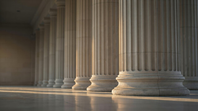 Row of classical stone columns on public building exterior with morning sunlight and long shadows