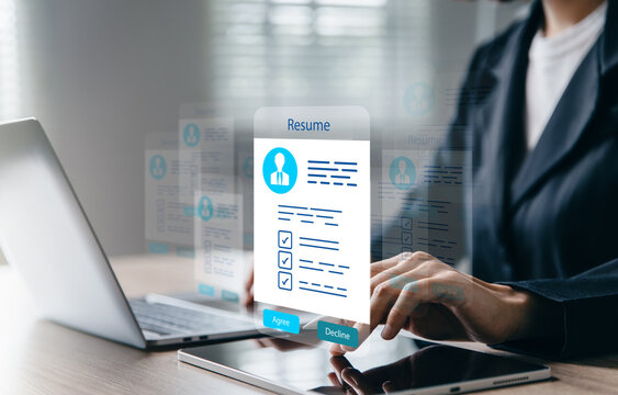 Recruiter reviews resumes on laptop.