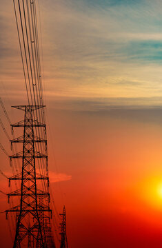 High voltage electricity transmission towers and power lines at sunset. Energy infrastructure, electrical grid, utility network, sustainable power supply and engineering. Renewable energy transition.