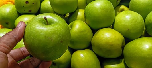 Group of ripe delicious shiny green apples for sale at traditional outdoor agricultural produce market © EfendyA