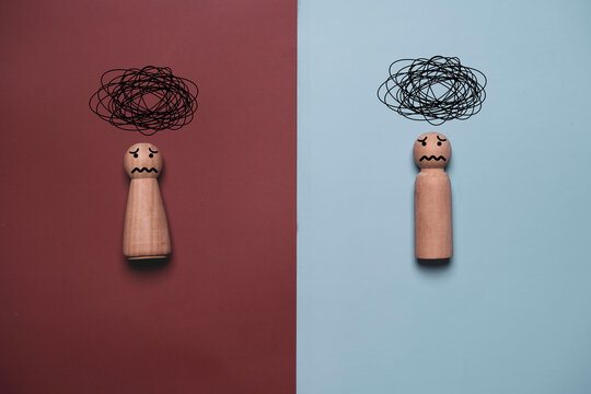 Two worried wooden man and woman with tangled thoughts for stress anxiety, overthinking, confusion, emotional pressure, mental overload, relationship problems, uncertainty and difficult communication.