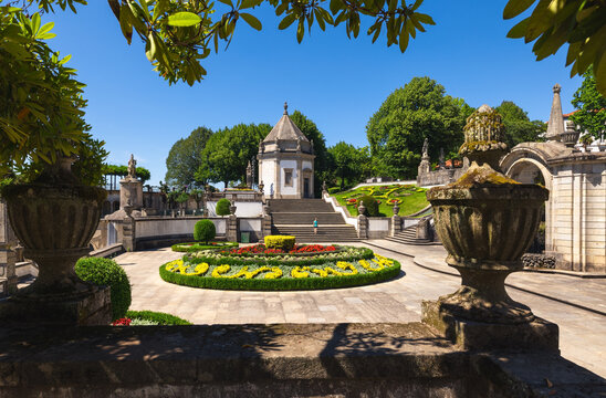 Braga, Braga, Portugal - 10 August 2026: View of Bom Jesus do Monte with its ornate stone staircase, manicured gardens, and historic chapel under a clear blue sky.
