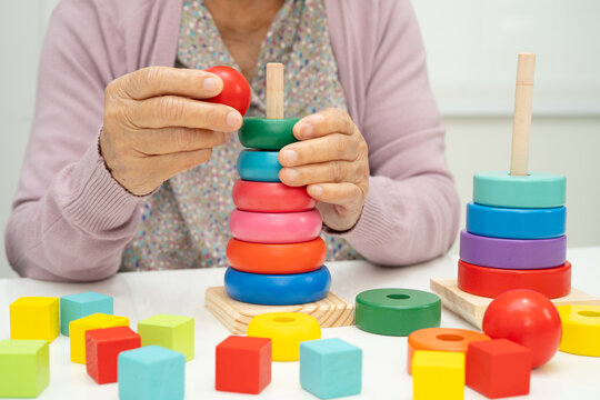 Asian elderly woman patient suffering from dementia learn practical motor skills rehabilitation.