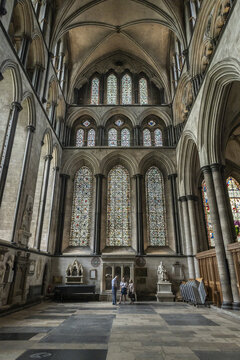 Salisbury, England, United Kingdom - 23 July 2026: View of Salisbury Cathedral interior with tall stained glass windows, stone arches, and visitors standing on the stone floor.