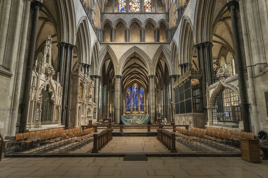 Salisbury, United Kingdom - 23 July 2026: View of the interior of Salisbury Cathedral featuring Gothic architecture, pointed arches, stained glass windows, and rows of wooden chairs.