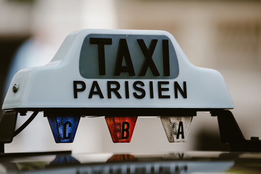 Paris, Ile-de-France, France - 06 May 2022: View of a taxi sign on a car roof in Paris, featuring the text Taxi Parisien and illuminated indicator lights labeled C, B, and A.