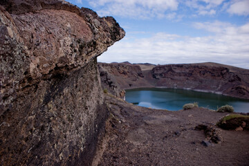 Laguna Azul volcanic crater lake surrounded by rugged volcanic rocks in Patagonia, Argentina. © Juan