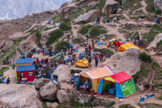 Karakoram Mountaine range, Gilgit Baltistan, Pakistan - 13 June 2007: View of Urdukas base camp with colorful tents and trekkers on the rocky terrain during the trek towards K2.
