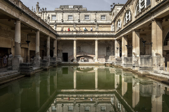 Bath, United Kingdom - 23 July 2026: View of the Roman Baths with its iconic green thermal water, classical columns, and stone architecture under a clear sky.