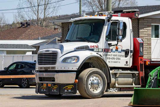La Tuque, Quebec, 16 May 2026 : White Freightliner truck with "Location d'Outils H.M. Auto Auriche" branding is parked on a street.