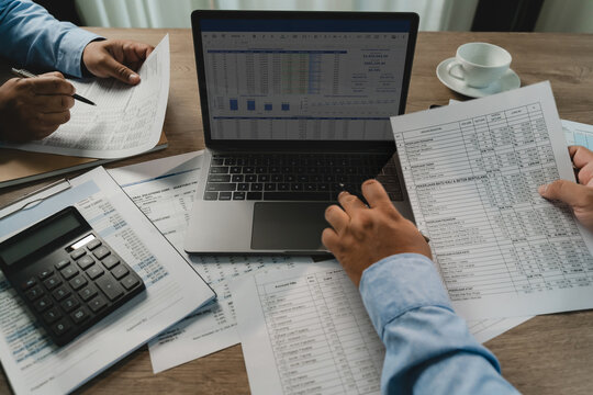 business meeting financial report financial reports around a laptop and calculator during a business meeting, showing data analysis, report checking, and accounting discussion report