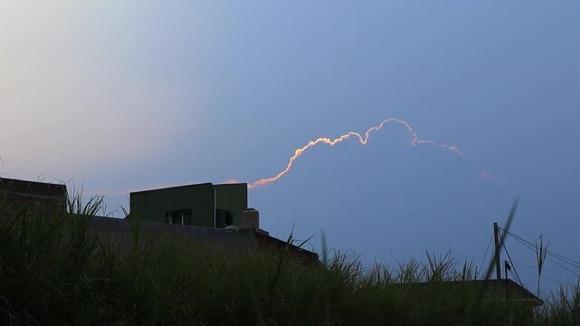 Golden cloud edge glowing at dusk over silhouetted rooftops, Indonesia