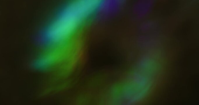 Bokeh glitter flare. Flicker light. Pink green blue color radiant illuminated rainbow flash on abstract optical art black luminous background.