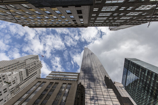 New York, United States - 03 October 2016: View of modern skyscrapers reaching towards a cloudy blue sky in the heart of the city.
