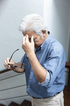 Asian elderly senior man with eyesight issue, concept image of aging eye sight, vision deterioration, cataract, glaucoma, eyesight impair, optical problem with eyeglasses, home indoor eye care