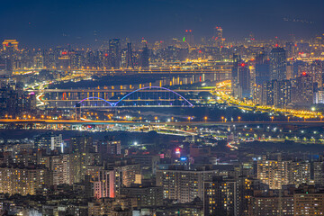 Fototapeta premium Illuminated bridges and dense Taipei skyline across the river at night