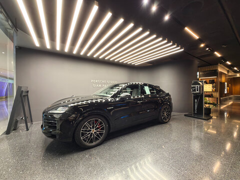 Bangkok, Thailand - May 31, 2026: Black Porsche Cayenne E Hybrid charging at showroom at Siam Paragon 