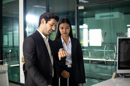 Business office colleagues discussing teamwork schedule and deadline as man checks watch beside woman, emphasizing time management, punctuality, planning and professional coordination