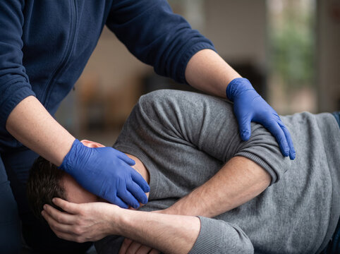 Emergency First Aid Responder Placing Injured Man in Recovery Position