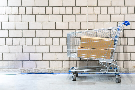 shopping cart with boxes in front of brick wall
