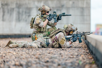 Fototapeta premium Military tactical team takes firing position behind rooftop cover during urban operation