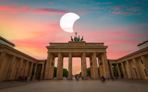 Brandenburg Gate in Berlin against conceptual dramatic sunset with solar eclipse and copy space