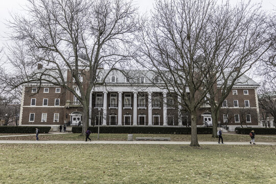 Champaign, Illinois, United States - 18 January 2017: View of the historic brick building at the University of Illinois Urbana-Champaign with bare trees and students on campus.