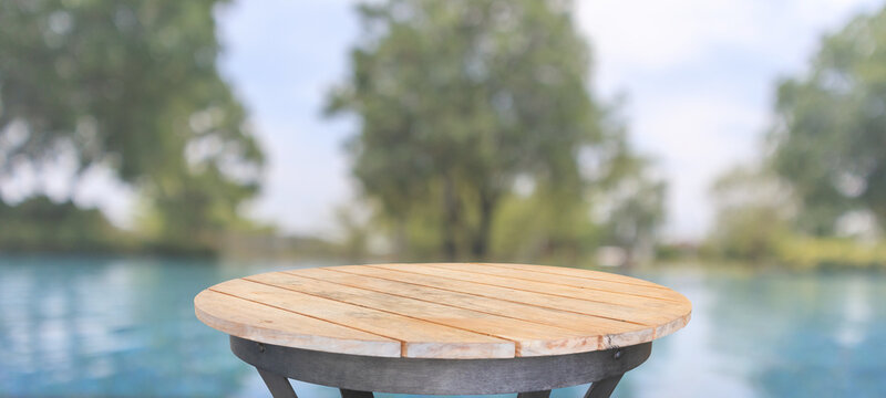 Empty round wood table top with blur outdoor swimming pool in tropical resort hotel summer background