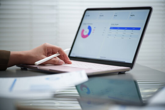 Professional reviewing a digital business dashboard on a laptop with charts, metrics and performance data, representing analytics, monitoring, reporting, strategy, planning, and productivity.