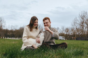 Obraz premium couple outdoors lifestyle dog meadow grass sweater happiness relaxed candid nature joyful affection companionship sunlight greenery field scenery moment bonding warmth park breeze comfort casual