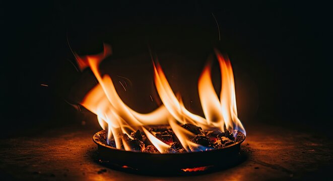 Close-up of flames dancing in a dark fireplace hearth.