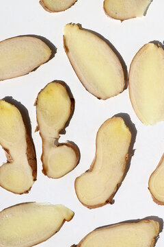 Sliced fresh ginger root on white background