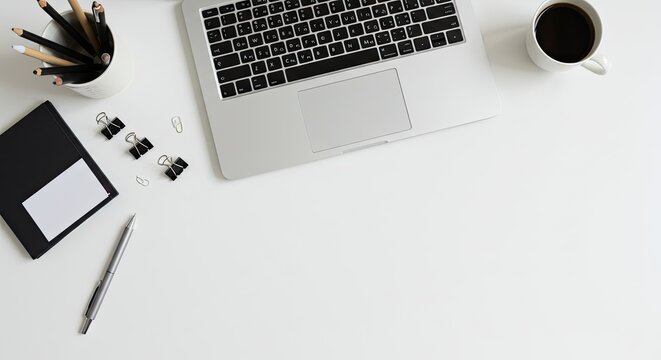 Modern workspace with laptop and accessories on desk.