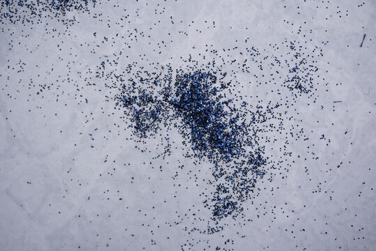 residuo de brillantina azul sobre piso blanco 