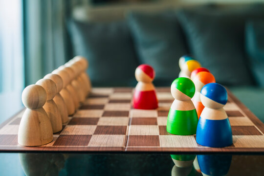 Wooden figures on chessboard facing each other in strategy board game, concept for business competition, team leadership, diversity, decision making, choice, and strategic plan.