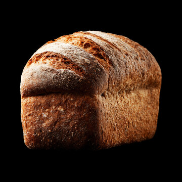 A rustic loaf of whole grain spelt bread on black background with clipping path, symbolizing bakery freshness and nourishment
