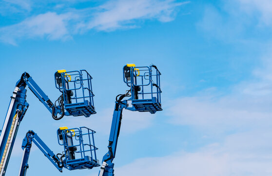 Articulated boom lift. Aerial platform lift. Telescopic boom lift against blue sky. Mobile construction crane for rent and sale. Maintenance and repair hydraulic boom lift service. Crane dealership.