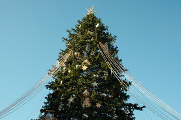 Obraz premium Christmas. Beautiful Christmas tree with ornaments and lights in outdoor space