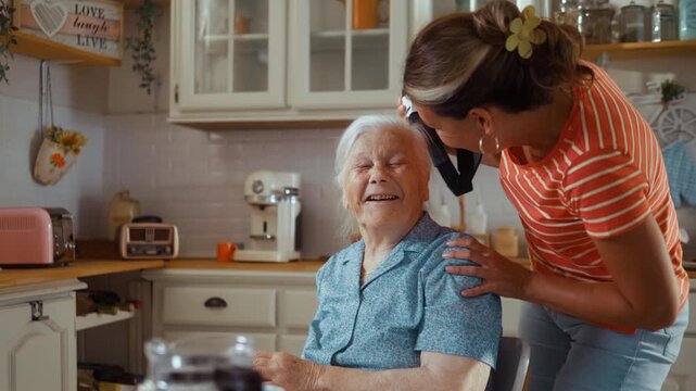 A woman assists an elderly woman in putting on a VR headset. The elderly woman smiles and reacts joyfully, expressing excitement. The scene transitions from the initial setup to laughter and engagemen