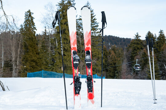 Ski gear positioned upright in snow with mountains in background