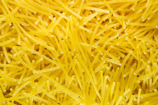 Macro Uncooked dry vermicelli pasta background full frame texture top view close up copy space flat lay top view. High quality