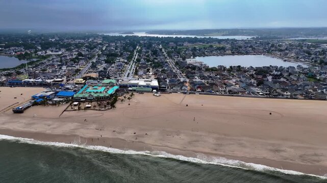 Aerial wide shot of Jenkinson Boardwalk beach and coastal town on an overcast day