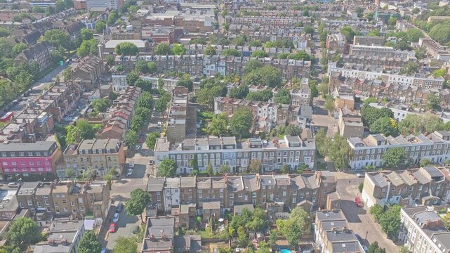 Wide Aerial drone of elegant Victorian and Edwardian terraced houses near Arsenal FC's Emirates Stadium in North London, England. The aerial view captures attractive period homes