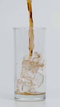 Slow Motion of Pouring Cola in Glass with Ice, White Background, Vertical Video