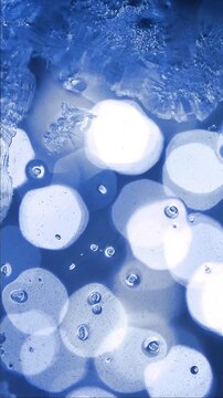 Vertical video of blue bokeh background covered by heavy frost texture