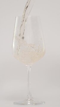 Slow Motion of Pouring Wine in Tilted Glass at 1000 fps, White Background, Vertical Video