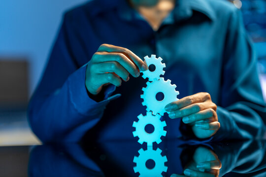 Hands holding connected gears, symbolizing teamwork, process, automation, and business coordination.