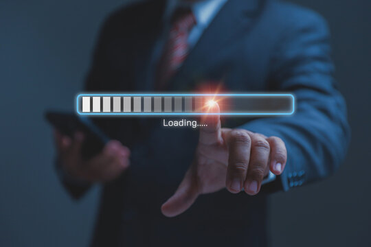 A professional businessman points his finger at a glowing digital loading bar. Smart digital tools make daily office work smooth and highly efficient.