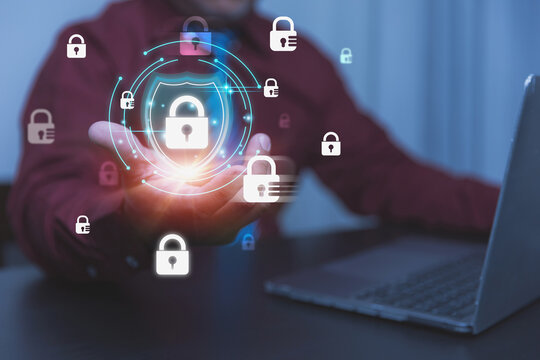 A businessman holds a glowing shield icon embedded with a secure padlock graphics element.