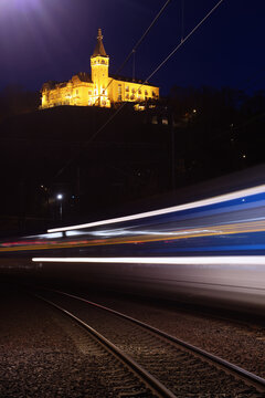 Vetruse.Usti nad Labem -Czech Republic.Passage of a night train on the railway line under the illuminated Castle Vetruse in town Usti nad Labem